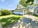 Charming two-story home featuring a well-maintained lawn, quaint porch, and long driveway at 417 S Oakland Ave, Indianapolis, IN 46201