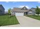 Charming single-Gathering home featuring a two-car garage, brick accents, and a well-manicured lawn at 4324 Homestead Dr, Whitestown, IN 46075