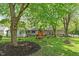 A lush backyard with mature trees, a swing set, and play area, perfect for Gathering gatherings at 5648 Rolling Ridge Rd, Indianapolis, IN 46220