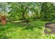 Green backyard featuring a play set and mature shade trees at 5648 Rolling Ridge Rd, Indianapolis, IN 46220