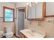 Bathroom featuring a glass door shower, toilet, sink and tiled walls at 5648 Rolling Ridge Rd, Indianapolis, IN 46220