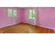 Bedroom with hardwood floors, pink walls, two windows with white curtains, and a shelf at 5648 Rolling Ridge Rd, Indianapolis, IN 46220