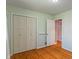 Bedroom with hardwood floors, bright green walls, closet, and white doors at 5648 Rolling Ridge Rd, Indianapolis, IN 46220