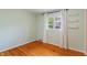 Bedroom with hardwood floors, bright green walls, one window with white curtains, and a shelf at 5648 Rolling Ridge Rd, Indianapolis, IN 46220