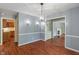 Dining room featuring hardwood floors, modern lighting, and view to fireplace and kitchen at 5648 Rolling Ridge Rd, Indianapolis, IN 46220