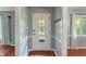 Inviting foyer with hardwood floors, soft gray walls, and a charming door featuring glass panes at 5648 Rolling Ridge Rd, Indianapolis, IN 46220