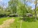 Charming front yard with mature trees, a lush lawn, and a stone path leading to the entrance at 5648 Rolling Ridge Rd, Indianapolis, IN 46220