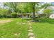 Charming ranch home with a stone walkway and a lush green lawn surrounded by mature trees at 5648 Rolling Ridge Rd, Indianapolis, IN 46220