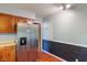 Kitchen with stainless steel refrigerator, wooden cabinetry, and view to side door at 5648 Rolling Ridge Rd, Indianapolis, IN 46220