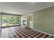 Light-filled sunroom with checkered floors, brick fireplace, and large windows at 5648 Rolling Ridge Rd, Indianapolis, IN 46220