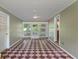 Sunroom with checkered tile floors, paneled walls and ceiling, and entrance to exterior at 5648 Rolling Ridge Rd, Indianapolis, IN 46220