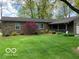 Charming stone home featuring lush landscaping and a well-maintained green lawn at 569 Meadow Dr, Danville, IN 46122