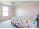 Bright bedroom with colorful floral bedding, soft carpet, and natural light from the window at 5770 Flagler Ln, Brownsburg, IN 46112