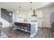 Bright kitchen with a large central island, bar stool seating, white cabinets, and stainless steel appliances at 5770 Flagler Ln, Brownsburg, IN 46112