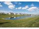 Tranquil view of a community pond surrounded by lush green lawn and newly built homes at 5770 Flagler Ln, Brownsburg, IN 46112