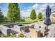 Outdoor patio with a firepit, stylish seating, and views of the landscaped backyard and pond at 6064 Bartley Dr, Noblesville, IN 46062
