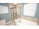 Bathroom with shower and soaking tub with natural lighting and neutral tile at 6064 Bartley Dr, Noblesville, IN 46062