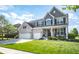 Charming two-story home with manicured lawn, three car garage and welcoming front porch at 6064 Bartley Dr, Noblesville, IN 46062