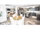 Modern open-concept kitchen with stainless steel appliances, dark cabinets, granite countertops and island breakfast bar at 6064 Bartley Dr, Noblesville, IN 46062