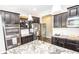 Close up view of a modern kitchen with stainless steel appliances and gray granite countertops and dark cabinets at 6064 Bartley Dr, Noblesville, IN 46062