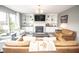 Cozy living room with a fireplace, TV, built in cabinets and large bright windows at 6064 Bartley Dr, Noblesville, IN 46062