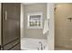 This bathroom showcases a soaking tub and shower, accentuated by neutral tones and natural light from the window at 6153 Dugan Dr, Whitestown, IN 46075