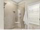 This bathroom features a glass-enclosed shower and an open doorway that reveals a walk-in closet with wire shelving at 6153 Dugan Dr, Whitestown, IN 46075