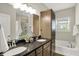 Modern bathroom with dual vanity, granite countertops, and a soaking tub, plus natural light at 6153 Dugan Dr, Whitestown, IN 46075