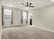 Large bedroom featuring neutral carpet, a ceiling fan, and ample natural light from the two windows at 6153 Dugan Dr, Whitestown, IN 46075