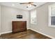 This bedroom features wood floors, a ceiling fan, and a stylish cabinet; a blend of comfort and modern design at 6153 Dugan Dr, Whitestown, IN 46075