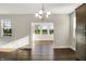 Bright dining room with a chandelier, large windows, and wood-look floors at 6153 Dugan Dr, Whitestown, IN 46075