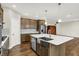 Contemporary kitchen features a stainless steel farmhouse sink, pendant lighting, and wood-look floors at 6153 Dugan Dr, Whitestown, IN 46075