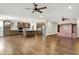 Open-concept living room with modern kitchen and fireplace, hardwood floors, and ceiling fans at 6153 Dugan Dr, Whitestown, IN 46075
