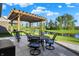 Outdoor patio with pergola overlooks lush lawn and pond, perfect for entertaining and enjoying waterfront views at 6153 Dugan Dr, Whitestown, IN 46075