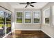 Bright sunroom with hardwood floors, ceiling fan, multiple windows, and sliding glass doors to the patio overlooking the water at 6153 Dugan Dr, Whitestown, IN 46075