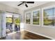 Bright sunroom with hardwood floors, ceiling fan, multiple windows, and sliding glass doors to the patio overlooking the water at 6153 Dugan Dr, Whitestown, IN 46075