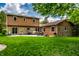Back exterior view of the home with stone accents, large windows and outdoor patio at 6938 Rio Grande Dr, Indianapolis, IN 46217
