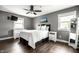 Cozy bedroom with gray walls, a ceiling fan, and natural light from two windows at 6938 Rio Grande Dr, Indianapolis, IN 46217