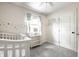 Bedroom with a white crib, light walls with star decor, and a window for natural light at 6938 Rio Grande Dr, Indianapolis, IN 46217
