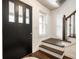 Bright foyer with hardwood floors, stairs, and a black front door with glass panes at 6938 Rio Grande Dr, Indianapolis, IN 46217