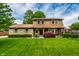 Charming two-story home featuring a stone facade, lush green lawn, and mature landscaping at 6938 Rio Grande Dr, Indianapolis, IN 46217