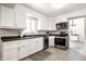 Bright kitchen features stainless steel appliances, white cabinetry, and gray tile floors at 6938 Rio Grande Dr, Indianapolis, IN 46217