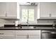 Well-lit kitchen with white cabinets, stainless steel sink, and modern fixtures at 6938 Rio Grande Dr, Indianapolis, IN 46217