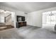Open living room with plush carpet, TV, and doorways to stairs and dining room at 6938 Rio Grande Dr, Indianapolis, IN 46217