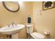 Cozy powder room with a pedestal sink, decorative mirror, and framed artwork at 6938 Rio Grande Dr, Indianapolis, IN 46217