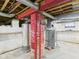 Utility basement featuring a water heater, red brick structural column, and exposed piping at 717 E 27Th St, Anderson, IN 46016