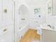 White tiled bathroom featuring a built-in tub, arched alcove, and a window at 717 E 27Th St, Anderson, IN 46016