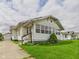 Quaint single-story home with weathered white siding, green lawn, and a detached garage at 717 E 27Th St, Anderson, IN 46016