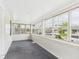 Bright sunroom featuring white wood paneling, gray carpet, and multiple windows with neighborhood views at 717 E 27Th St, Anderson, IN 46016