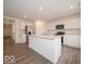 Open-concept kitchen with stainless steel appliances, white cabinetry, and a large center island at 7509 Big Bend Blvd, Camby, IN 46113